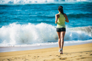 Woman jogging on the beach for self-care