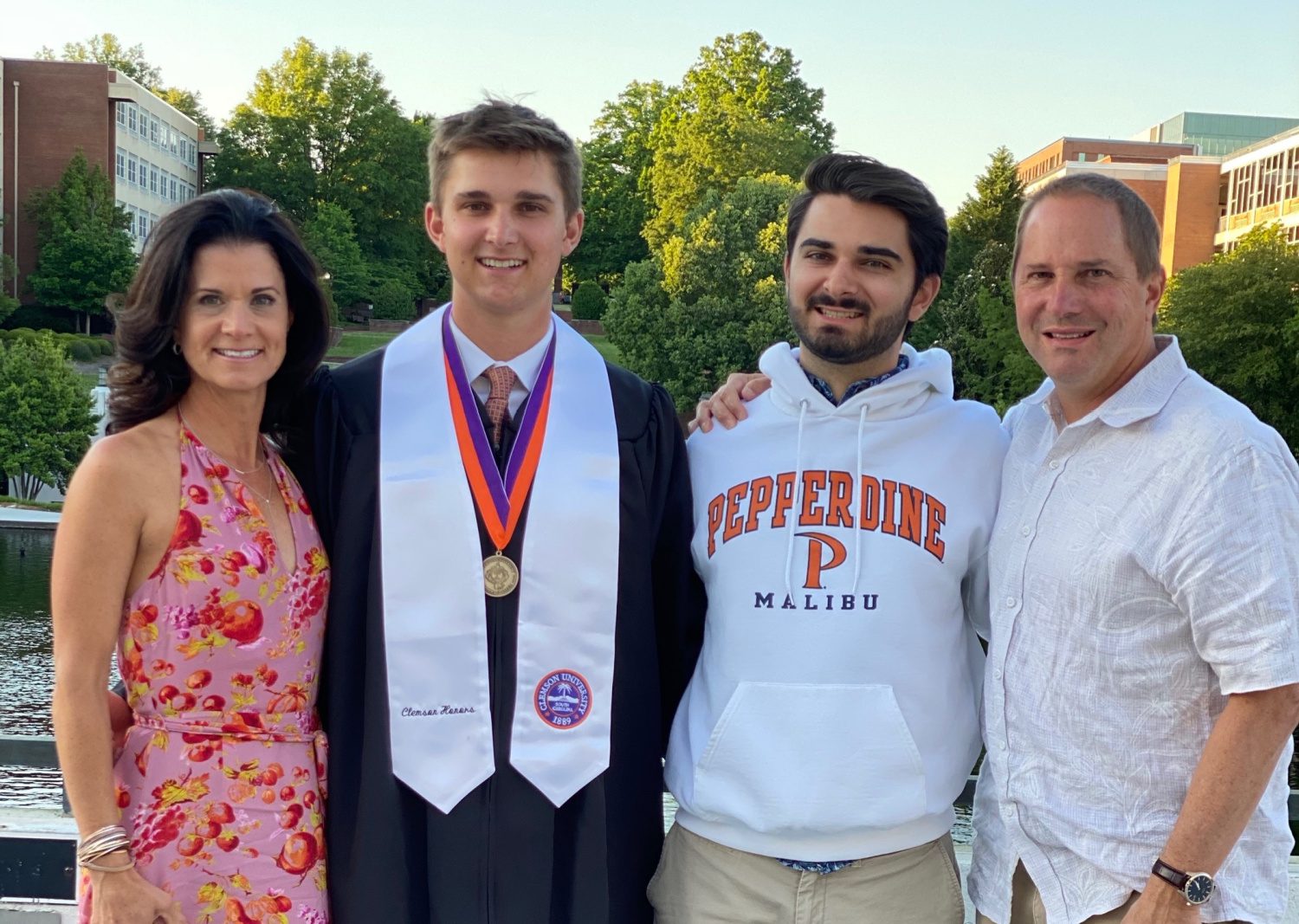 Steph, her two sons and husband, smiling at the camera on her son's graduation day